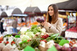 Young woman buying vegetables at the market