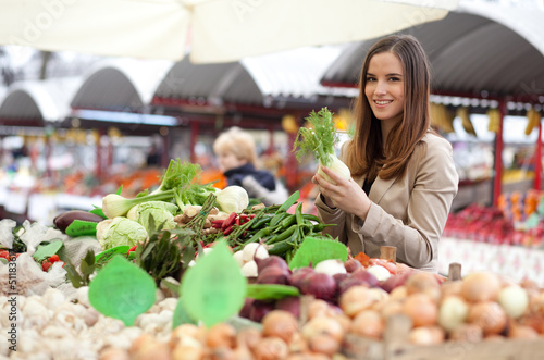 Photo: Young woman buying vegetables at the market Young woman buying vegetables at the market