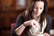 Photo: Woman stirring a cup of cappuccino Woman stirring a cup of cappuccino