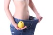 Junge Frau in zu großer Hose mit Apfel