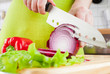 Woman's hands cutting bulb onion