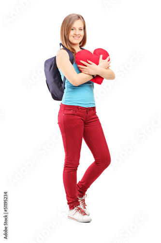 Photo: Full length potrait of a female student with backpack holding a Full length potrait of a female student with backpack holding a