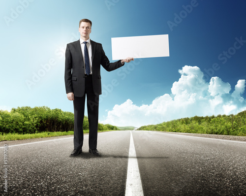 Photo: business man on the road whith blank in hand business man on the road whith blank in hand