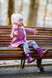 Young girl sitting on a wooden bench
