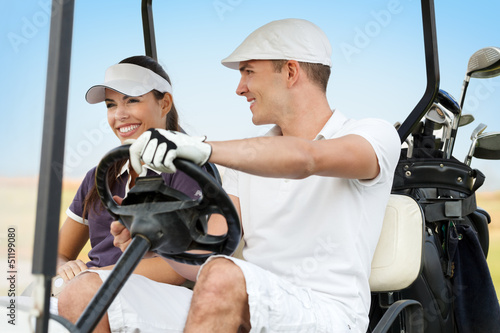 Photo: Happy young couple on golf course Happy young couple on golf course