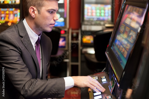 Photo: Men gambling in the casino on slot machines Men gambling in the casino on slot machines