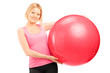 A blond female athlete holding a pilates ball