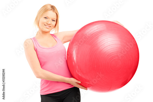 Photo: A blond female athlete holding a pilates ball A blond female athlete holding a pilates ball
