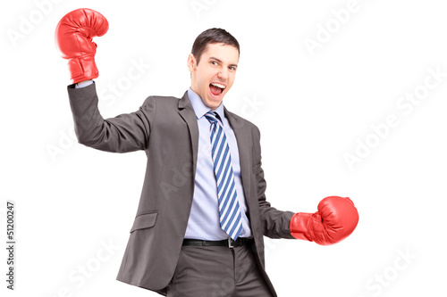 Photo: A businessman wearing red boxing gloves and gesturing happiness A businessman wearing red boxing gloves and gesturing happiness