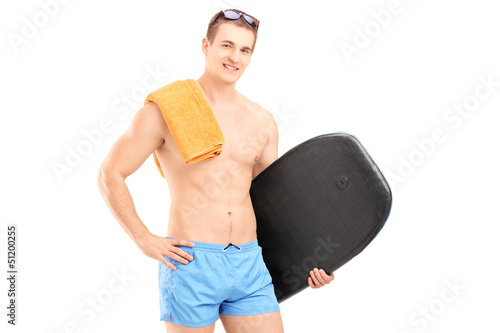 Photo: A hadsome man in a swimming suit holding a surfing board A hadsome man in a swimming suit holding a surfing board