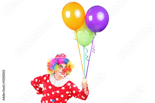 Photo: A male clown in costume holding bunch of balloons A male clown in costume holding bunch of balloons