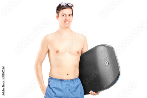 Photo: A male surfer holding a surfboard and posing A male surfer holding a surfboard and posing