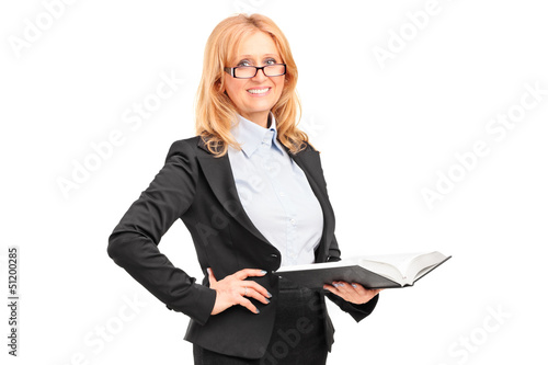 Photo: A smiling female teacher holding a notebook A smiling female teacher holding a notebook