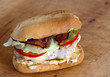 Small sandwich with bacon, cheese, tomatoes, onion and lettuce.