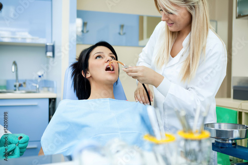 Photo: Dentists assisting a female patient Dentists assisting a female patient