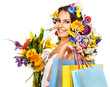 Woman with shopping bag holding flower.