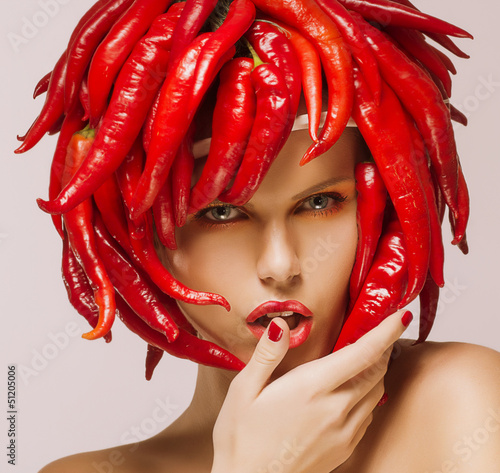Photo: Hot Chili Pepper on Shiny Woman's Face. Creative Concept Hot Chili Pepper on Shiny Woman's Face. Creative Concept