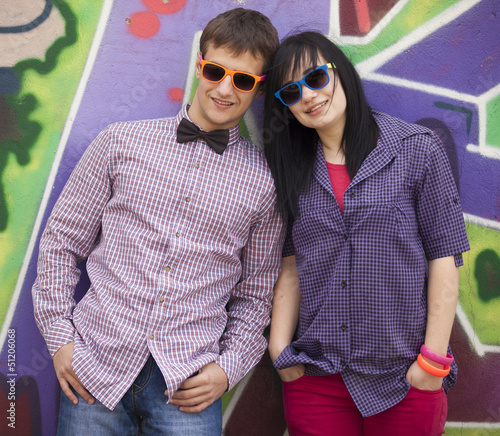 Photo: Style teen couple near graffiti background. Style teen couple near graffiti background.