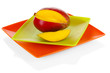 Ripe appetizing mango on red plate isolated on white
