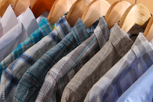 Photo: Men's shirts on hangers in wardrobe Men's shirts on hangers in wardrobe
