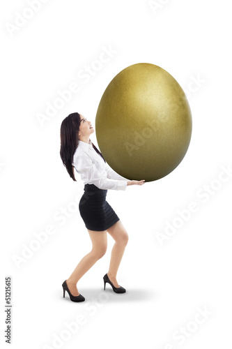 Photo: Businesswoman carry golden egg - isolated Businesswoman carry golden egg - isolated