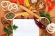 Notebook for recipes, vegetables and spices on wooden table.