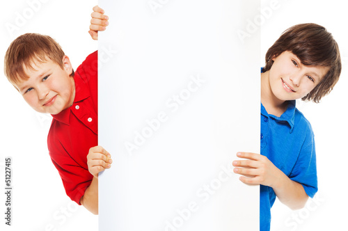 Photo: Close-up of boys showing new blank advertising Close-up of boys showing new blank advertising