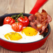 Fried eggs with bacon and tomatoes
