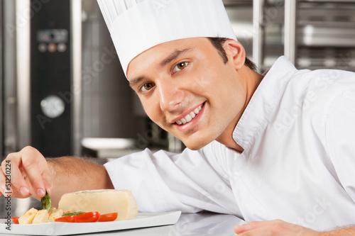 Photo: Happy Male Chef Garnishing Dish Happy Male Chef Garnishing Dish