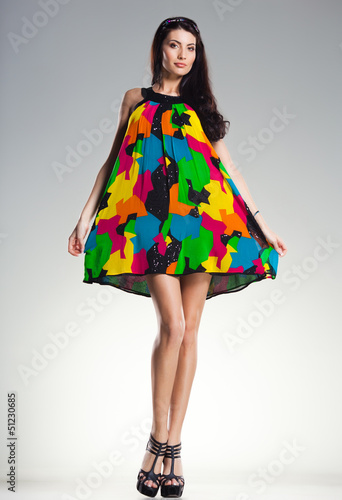 Photo: sexy woman wearing colorful summer dress on light grey sexy woman wearing colorful summer dress on light grey