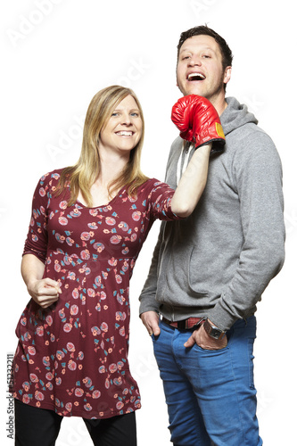 Photo: Young couple fighting with boxing gloves smiling Young couple fighting with boxing gloves smiling