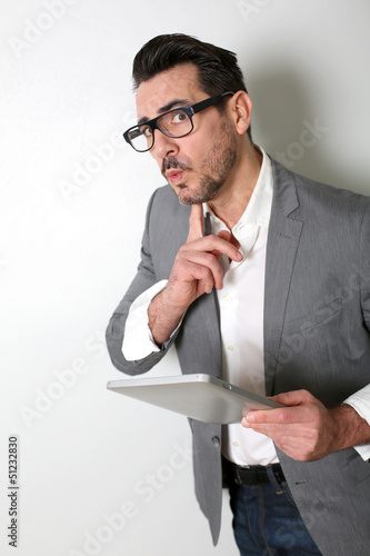 Photo: Man using tablet with questioning look Man using tablet with questioning look