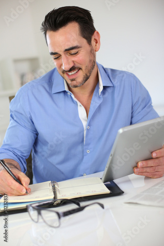 Photo: Smiling businessman working from home Smiling businessman working from home