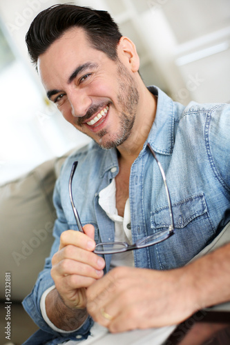 Photo: Funny mature man holding eyeglasses Funny mature man holding eyeglasses