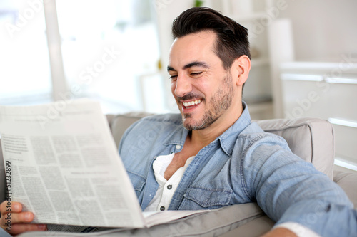 Photo: Man relaxing at home with newspaper Man relaxing at home with newspaper
