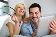 Cheerful couple websurfing on internet with tablet