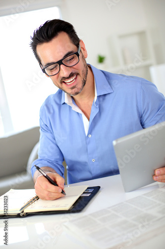 Photo: Smiling businessman working from home Smiling businessman working from home
