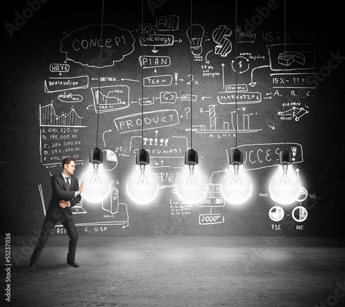 Photo: businessman pushing bulbs businessman pushing bulbs