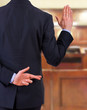 Business man with fingers crossed.