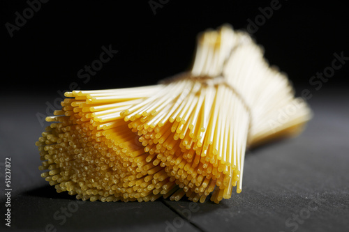 Photo: Raw pasta on black table Raw pasta on black table