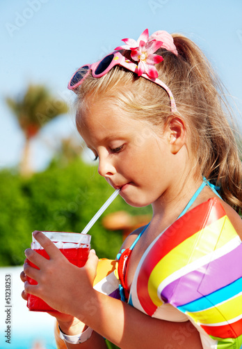 Photo: Child drinking near swimming pool. Child drinking near swimming pool.