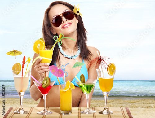 Photo: Girl in bikini on beach drinking cocktail. Girl in bikini on beach drinking cocktail.
