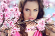 Stare. Outdoors portrait of beautiful woman model in pink blosso