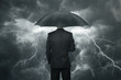Businessman with umbrella standing in the rain