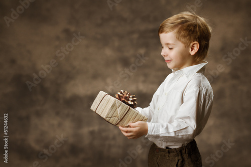 Photo: Child holding gift box. Vintage style. Child holding gift box. Vintage style.