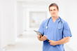A male medical doctor in a uniform holding a clipboard and posin