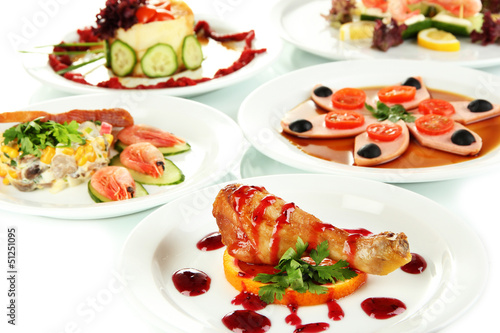 Photo: Small portions of food on big white plates close up Small portions of food on big white plates close up