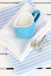 Blue jug with milk on napkin on wooden picnic table close-up