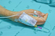 IV solution in a patients hand. Focus on hand