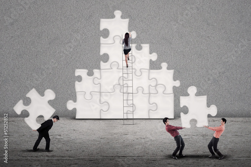 Photo: Business teamwork building puzzle Business teamwork building puzzle
